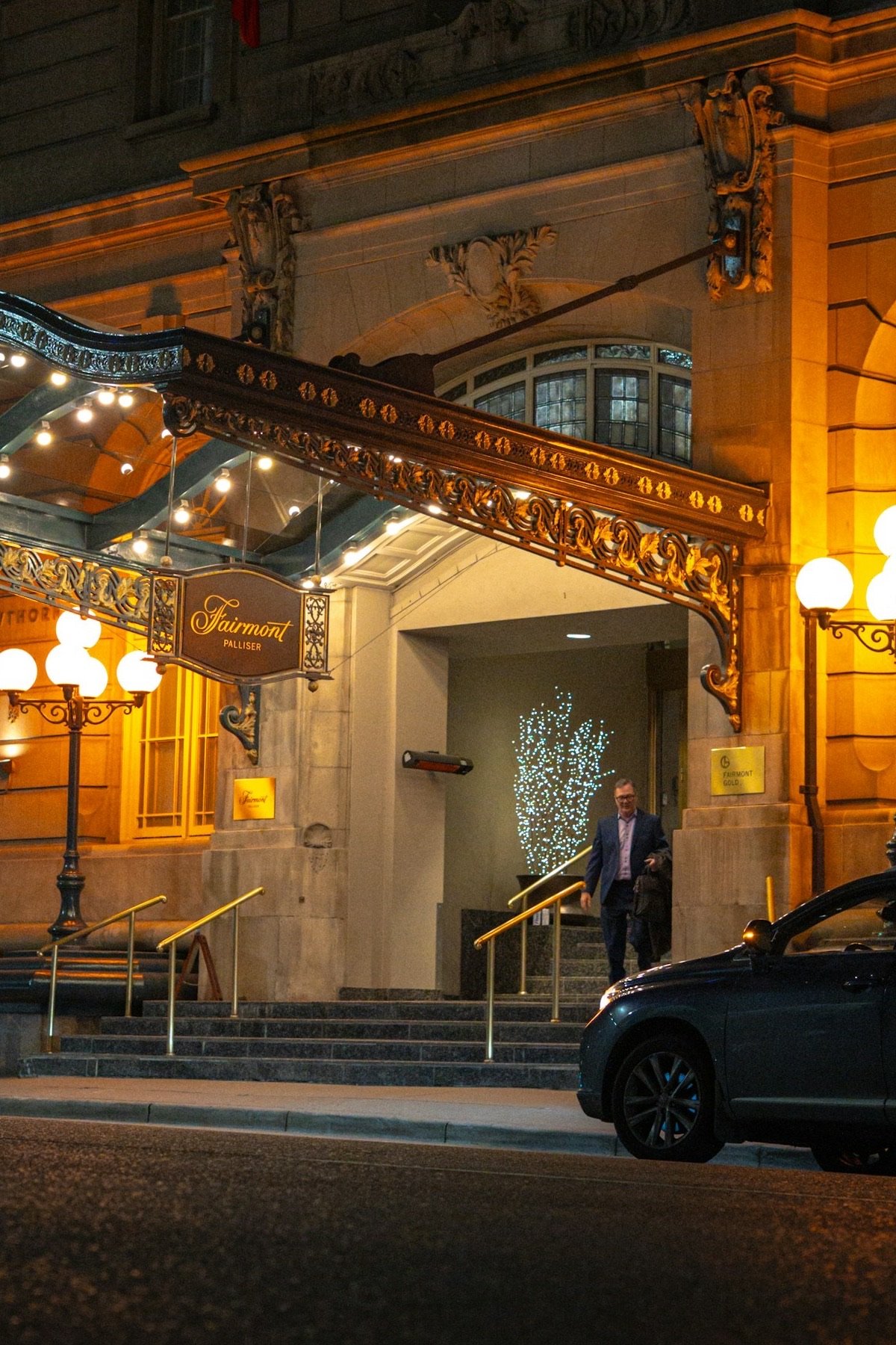 Berline devant l'entrée éclairée d'un hôtel le soir